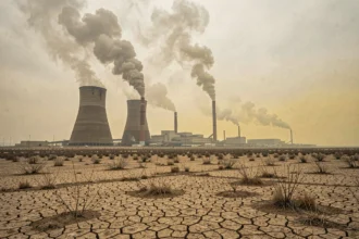 Centrale à charbon polluante avec cheminées fumantes dans un paysage industriel dégradé et smog visible